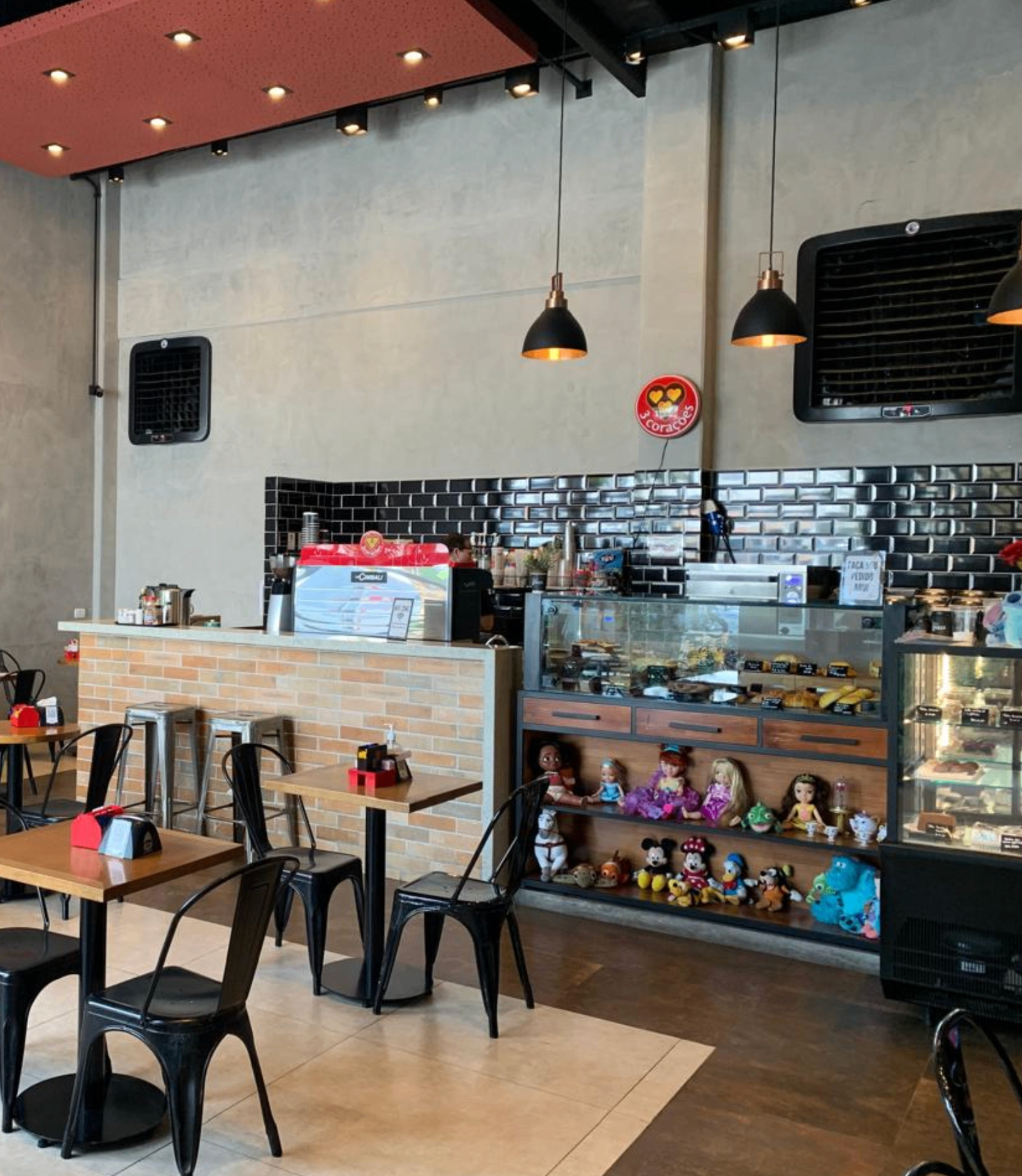 Canto aconchegante de cafeteria paulistana com cadeira vintage, mesa redonda e xícara de café ao lado de uma janela