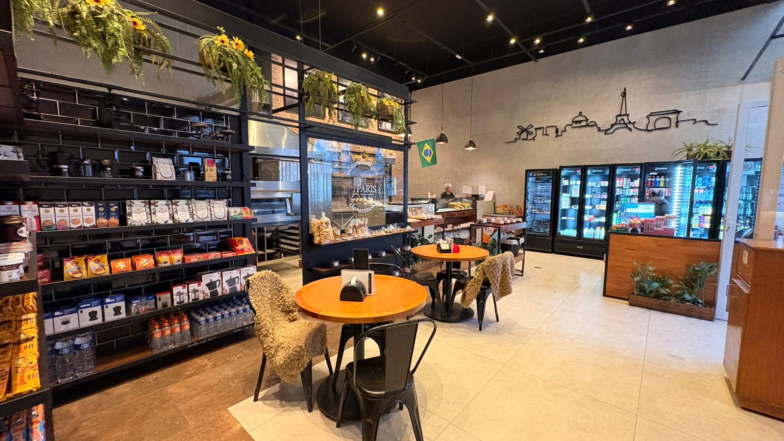 Canto aconchegante de cafeteria paulistana com cadeira vintage, mesa redonda e xícara de café ao lado de uma janela